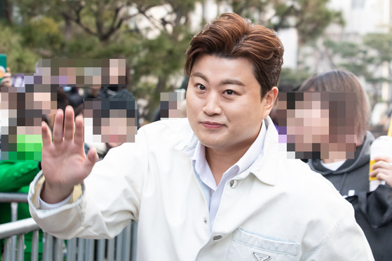 Trot and popera singer Kim Ho-joong greets fans as he enters a building last February. Kim appeared for questioning at Seoul Gangnam Police Station at around 2 p.m. on Tuesday regarding allegations he was involved in a drunk hit-and-run incident. [NEWS1]