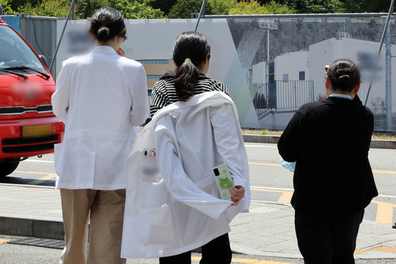 Medical professionals walk on a compound of a general hospital in downtown Seoul on Tuesday. [NEWS1] 
