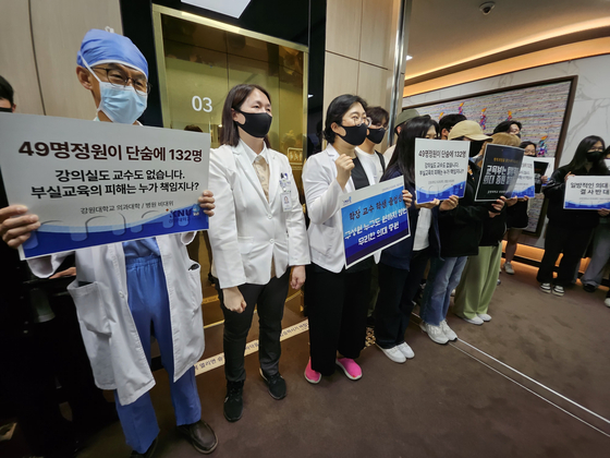 Medical professors at Kangwon National University picket in front of a meeting hall on campus in Gangwon on Tuesday, demanding the admissions quota hike in medical schools to be scrapped. [NEWS1]