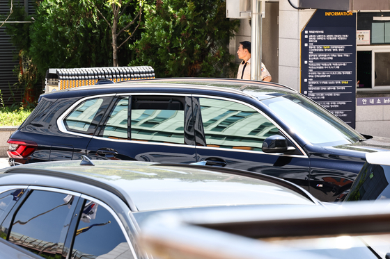 A vehicle presumed to be carrying Kim Ho-joong leaves the police station on Tuesday. [JOONGANG ILBO] 