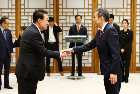 President Yoon Suk Yeol, left, shakes hands with new Japanese Ambassador to Korea Koichi Mizushima after receiving his credentials during a ceremony at the Yongsan presidential office in central Seoul Tuesday. [JOINT PRESS CORPS]