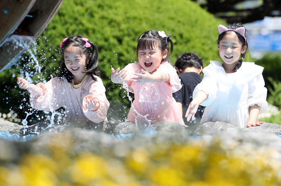 Children splash water at a pond near Gwangju's Buk District Office as the area experiences early summer weather on Tuesday. Midday highs in Gwangju rose to 28.4 degrees Celsius (83.1 degrees Fahrenheit) the same day, according to the Korea Meteorological Administration. [BUK DISTRICT OFFICE]