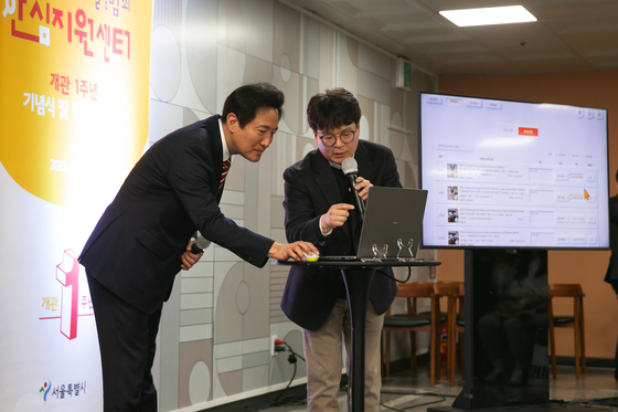 Seoul Mayor Oh Se-hoon, left, tries out the city's AI system that automatically detects sexually exploitative material during an anniversary event of the capital's digital sex crime support center in southern Seoul held in March last year. [SEOUL METROPOLITAN GOVERNMENT]