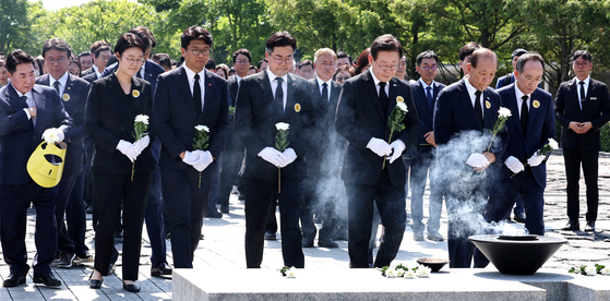 From left: New Future Party leader Lee Seok-hyun, Progressive Party Secretary General Yoon Hee-suk, Progressive Party leader Kim Jun-woo, Democratic Party (DP) floor leader Park Chan-dae, DP leader Lee Jae-myung, People Power Party (PPP) interim leader Hwang Woo-yea and PPP floor leader Choo Kyung-ho lay wreaths at the grave of late President Roh Moo-hyun at Bonghwa Village, South Gyeongsang, on Thursday, the 15th anniversary of his death. [NEWS1]