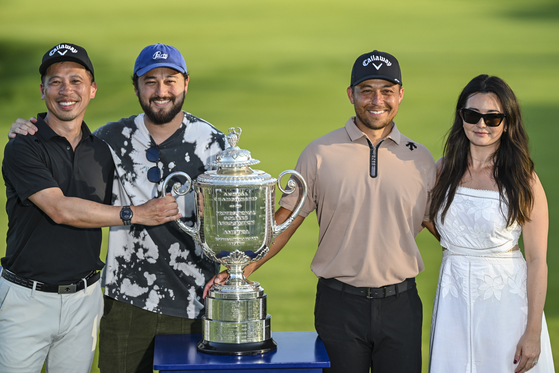 Xander Schauffele and his family members, from left, uncle Gao-Ya Chen, brother Nico Schauffele and wife Maya Schauffele smile with the Wanamaker Trophy after his one-stroke victory in the final round of the PGA Championship at Valhalla Golf Club on May 19 in Louisville, Kentucky. [GETTY IMAGES]