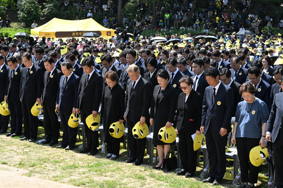 Politicians from across the aisle observe a moment of silence at a ceremony commemorating former President Roh Moo-hyun on the 15th anniversary of his death at his gravesite in Bonghwa Village, South Gyeongsang, on Thursday. Prime Minister Han Duck-soo stands second from left in the front row, while former President Moon Jae-in and former first lady Kim Jung-sook stand fifth and fourth from right. [NEWS1]