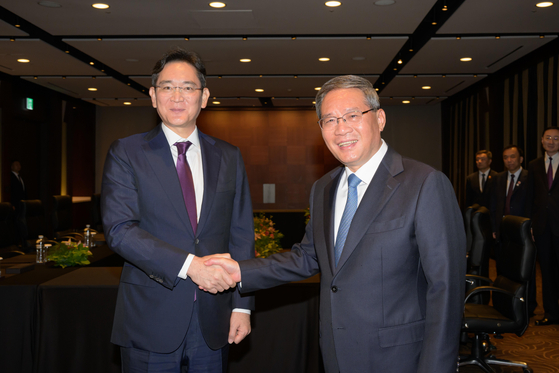 Samsung Electronics Executive Chairman Lee Jae-yong, left, shakes hands with Chinese Premier Li Qiang after a meeting held in central Seoul on Sunday. [SAMSUNG ELECTRONICS]