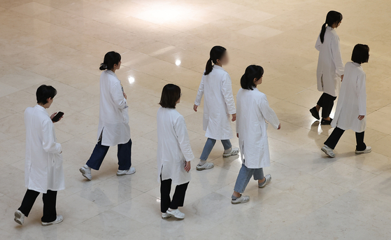 Seven doctors walk inside a general hospital in Seoul on Sunday. [NEWS1]
