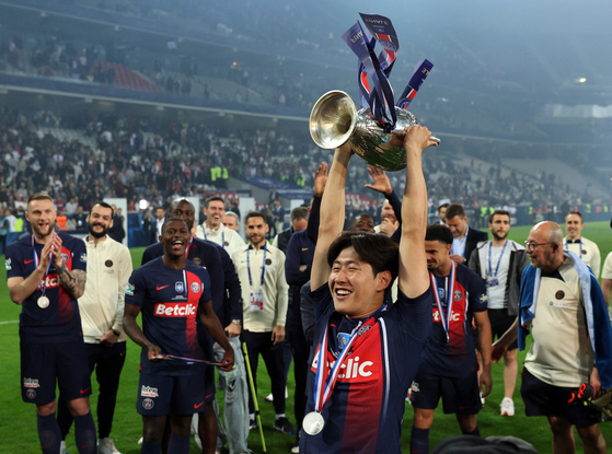 Lee Kang-in lifts the French Cup trophy after Paris Saint-Germain beat Lyon 2-1 in the final at Stade Pierre-Mauroy in France on Saturday. [REUTERS/YONHAP] 