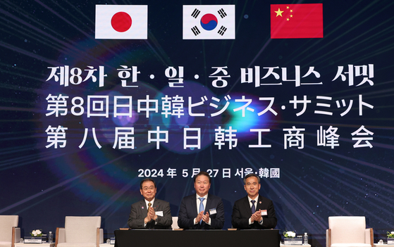 SK Group Chairman Chey Tae-won, head of the Korea Chamber of Commerce and Industry (KCCI), center, Masakazu Tokura, left, chairman of the Japan Business Federation, and Ren Hongbin, right, chairman of the China Council for the Promotion of International Trade (CCPIT), sign a joint statement on trilateral economic cooperation at the KCCI headquarters in central Seoul on Monday. [NEWS1]