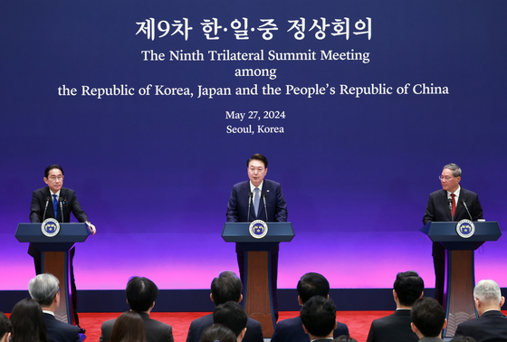 President Yoon Suk Yeol, center, speaks during a joint press briefing after holding a trilateral summit with Japanese Prime Minister Fumio Kishida, left, and Chinese Primer Li Qiang, right, at the Blue House in central Seoul on Monday. [JOINT PRESS CORPS]