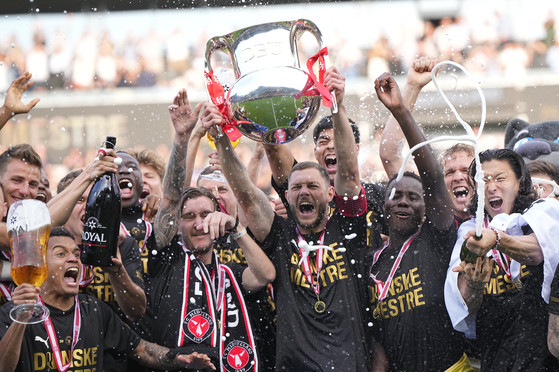 FC Midtjylland's players celebrate winning the Danish Superliga trophy at MCH Arena in Herning, Denmark on Sunday. Cho Gue-sung, right, pops a champagne bottle. [AP/YONHAP]
