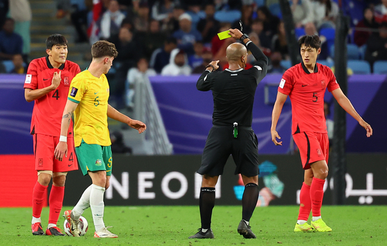 Korea defender Kim Min-jae, left, is flashed a yellow card during a match against Australia in the quarterfinals of the AFC Asian Cup in Qatar on Feb. 2, 2024. [YONHAP]