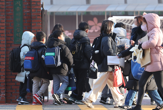 Children walk to school at an elementary school in Seoul on March 4 [NEWS1]