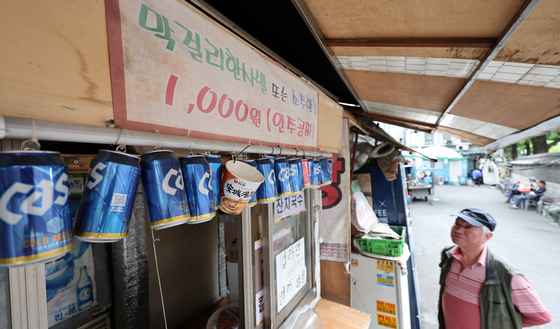 A sign at a cart bar in central Seoul on Tuesday reads it sells makgeolli (rice wine) and soju by the glass. [NEWS1]