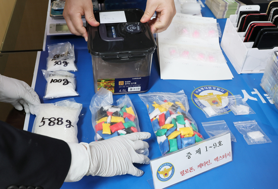 Police show drugs and phones confiscated from a voice phishing ring also accused of trafficking drugs in Korea at Dongdaemun Police Station in eastern Seoul on Wednesday. [YONHAP]