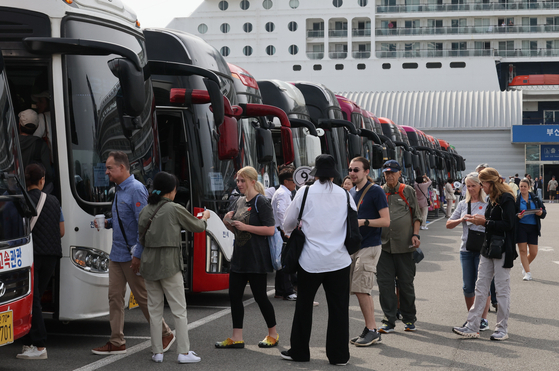 Passengers from the Celebrity Millennium cruise ship board buses to visit tourist spots in Busan on May 22. [SONG BONG-GEUN] 