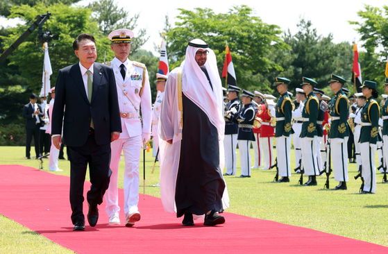 President Yoon Suk Yeol, left, and United Arab Emirates (UAE) President Mohamed bin Zayed Al Nahyan inspect the Korean honor guard at the lawn in front of the Yongsan presidential office during an official welcome ceremony on Wednesday ahead of their bilateral summit. [PRESIDENTIAL OFFICE]