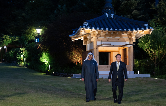  President Yoon Suk Yeol, right, takes a stroll with United Arab Emirates President Mohamed bin Zayed Al Nahyan in the gardens of the presidential residence in Hannam-dong, central Seoul, for a friendly chat to wrap up the UAE leader’s two-day trip to Korea Wednesday. [PRESIDENTIAL OFFICE] 