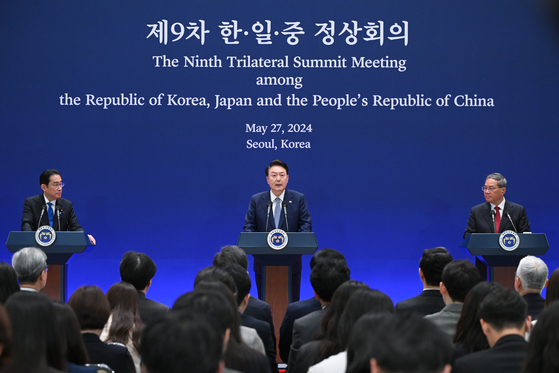 President Yoon Suk Yeol, center, speaks during a joint press briefing after holding a trilateral summit with Japanese Prime Minister Fumio Kishida, left, and Chinese Primer Li Qiang, right, at the Blue House in central Seoul on Monday. [JOINT PRESS CORPS] 