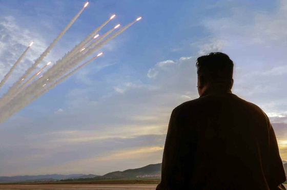 North Korean leader Kim Jong-un oversees the country's ″power demonstration firing″ of 600 mm (23.6 inch) super-large multiple rocket launchers the previous day, in a photo carried by its official Korean Central News Agency on Friday. [YONHAP]