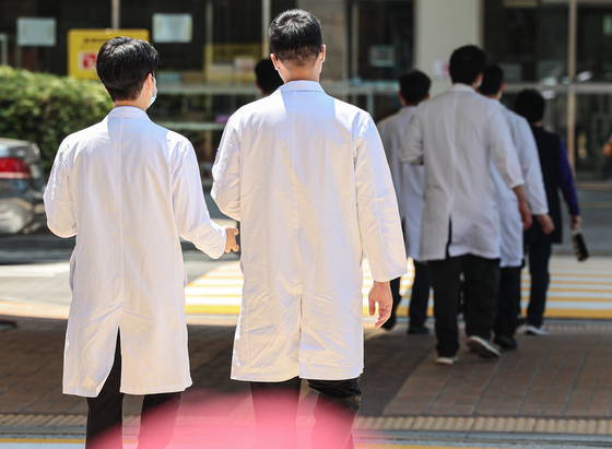 Doctors walk near a hospital in Seoul on Friday. [NEWS1] 