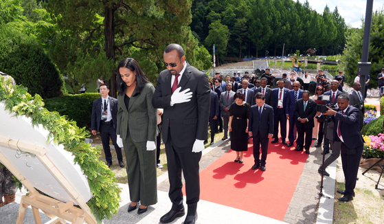 Ethiopian Prime Minister Abiy Ahmed, right, and his wife, Zinash Tayachew, pay respect at the Korean War Memorial in Chuncheon, Gangwon, on Sunday. [YONHAP]