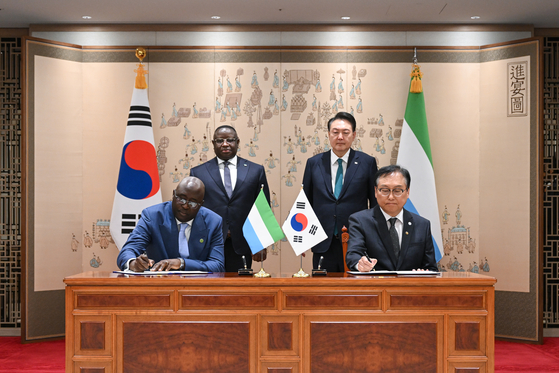 Korean President Yoon Suk Yeol, back right, and Sierra Leone's President Julius Maada Bio, back left, watch their trade ministers sign a memorandum of understanding at a ceremony at the Yongsan presidential office in central Seoul on Friday. [PRESIDENTIAL OFFICE]