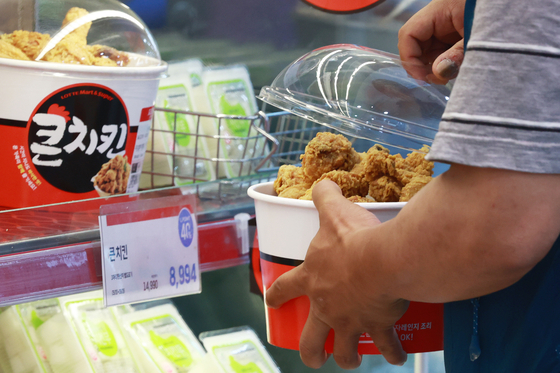 A man picks out his chicken bucket at a discount mart in downtown Seoul on Sunday. [YONHAP]