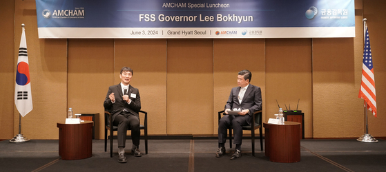 Financial Supervisory Service (FSS) Gov. Lee Bok-hyun, left, and American Chamber of Commerce in Korea Chairman James Kim speak during a dialogue session held in central Seoul on Monday. [FSS]