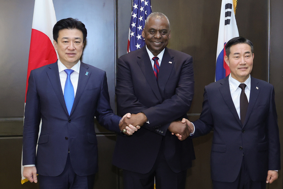 South Korean Defense Minister Shin Won-sik, right, shakes hands with U.S. Secretary of Defense Lloyd Austin, center, and Japanese Defense Minister Minoru Kihara before their talks on the sidelines of the Shangri-La Dialogue in Singapore on Sunday. [YONHAP]