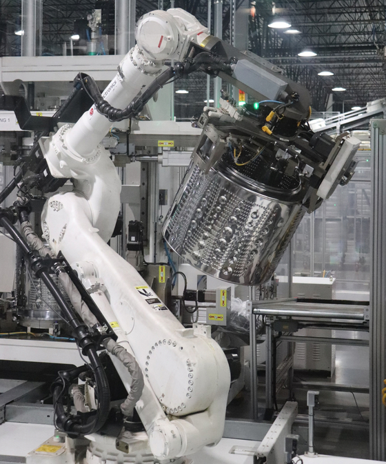 A robot arm picks up a washing machine bucket at LG Electronics' manufacturing plant in Tennessee. The Korean electronics maker said it is considering making other home appliances at the plant on top of its washing machines and dryers. Market conditions are uncertain ahead of the U.S. presidential election scheduled for November.[YONHAP]