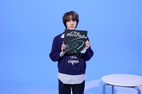 BTS member Jin holds up his single ″The Astronaut″ (2022). [BIG HIT MUSIC]