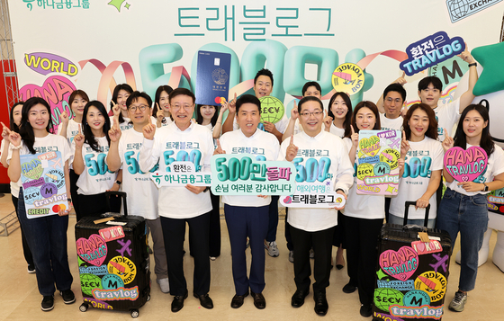Hana Financial Group Chairman Ham Young-joo, fifth from left in the first row, poses for a photo during a ceremony held at Hana Bank's headquarters in central Seoul on Tuesday celebrating Travlog's 5 million subscriber milestone, with Hana Bank CEO Lee Seung-lyul, fourth from left, and Hana Card CEO Lee Ho-sung, sixth from left. [HANA FINANCIAL GROUP]