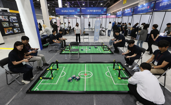 Visitors play robot football at the 19th Korea Assistive Technology Device Fair held at the aT Center in Seocho District, southern Seoul on Tuesday. [YONHAP] 