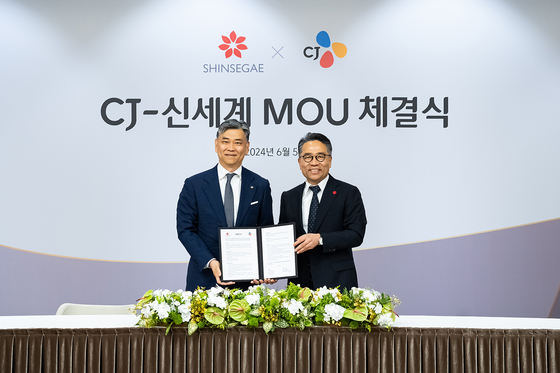 CJ Corporation CEO Kim Hong-ki, left, and Im Young-rok, CEO of Shinsegae Property and Josun Hotels & Resorts, pose for a photo at the two companies’ memorandum of understanding (MOU) signing ceremony held on Wednesday. [SHINSEGAE]