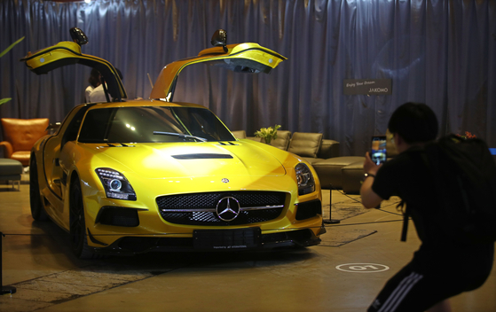 Visitors take a look at supercars at the Mens Festa exhibition at Coex in southern Seoul. [YONHAP] 