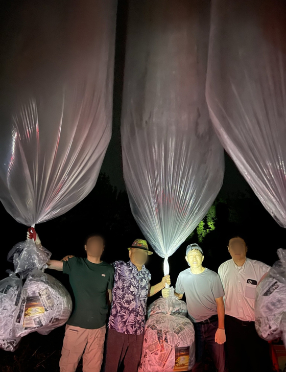 Activists from Fighters for a Free North Korea hold up balloons filled with anti-Pyongyang leaflets, USB sticks and U.S. dollars before launching them into the North from an undisclosed site in Pocheon, northern Gyeonggi, on Thursday. [YONHAP]