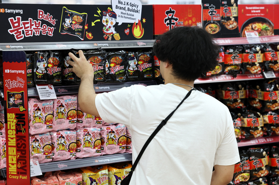 A shopper picks up a packet of Buldak Ramen at a supermarket in Seoul. [NEWS1]