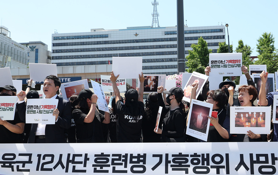 Families of current and former trainee soldiers and officials from the Center for Military Human Rights protest in front of the Defense Ministry building in Yongsan District, central Seoul, on Tuesday. [YONHAP]