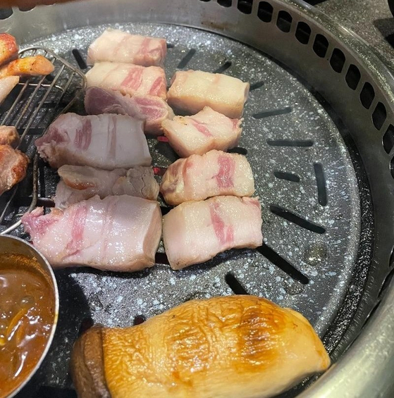 An online user shares a photo of fatty pork belly cuts on the grill in online community Bobaedream in late April, which sparked a heated debate. [SCREEN CAPTURE]