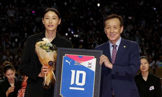 Oh Han-nam, president of the Korea Volleyball Association, hands Kim Yeon-koung her No. 10 national team uniform during a retirement ceremony on Saturday. Kim's uniform also hands in the Olympic Museum in Lausanne, Switzerland.  [NEWS1]