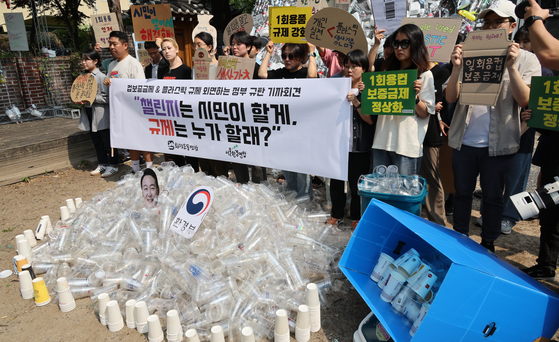 Civil environmental organizations protest the government's refusal to implement the single-use cup tax and regulations on the use of plastic in a news conference held in front of the Korea Federation for Environmental Movements in Jongno District, central Seoul, on Monday. [YONHAP]