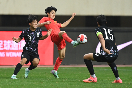 Yusufu Amuti of China, center, controls the ball during a friendly between the U-19 teams of China and Korea in Weinan, China on June 10.  [XINHUA/YONHAP]