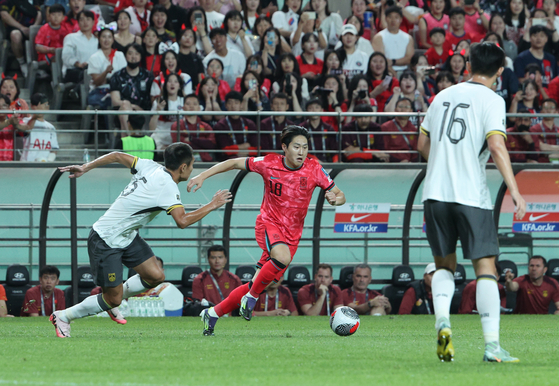 Korea's Lee Kang-in, center, dribbles during the second round World Cup qualifier match against China at Seoul World Cup Stadium in western Seoul on Tuesday. [NEWS1]