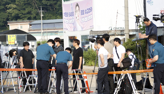 Reporters get ready to take pictures of Jin as he walks out from the training center on Wednesday. [NEWS1] 