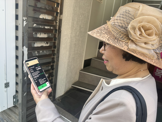 Choi Seoung-hee, a 66-year-old "N-jobber" from Dongdaemun District in eastern Seoul, recently looks at the phone she uses when working. N-jobbers refer to a person who holds an ″N″ number of jobs. [SEOUL METROPOLITAN GOVERNMENT]