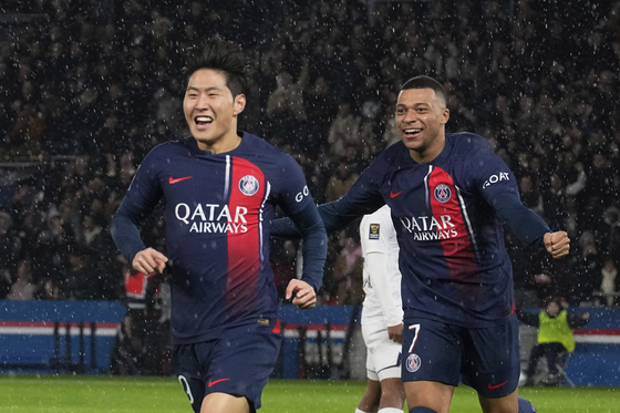 Paris Saint-Germain midfielder Lee Kang-in, left, celebrates with Kylian Mbappe after scoring his side's first goal during the French Super Cup final against Toulouse at the Parc des Princes in Paris, France on Jan. 3. [AP/YONHAP] 