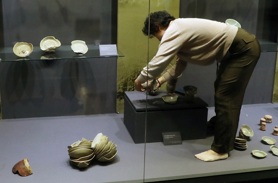 An employee at the Buan Celadon Museum clears an exhibition space of debris after the earthquake on Wednesday. [NEWS1]