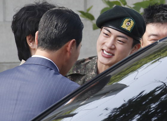 Jin with teary eyes as he says goodbye to some of the officials from the army on Wednesday [NEWS1] 